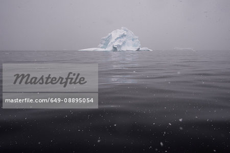 Snowfall over icebergs in Portal Point, Antarctica