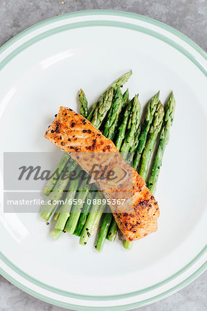Grilled salmon fillet on a bed of green asparagus