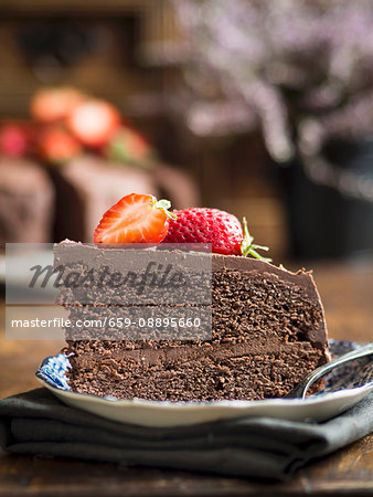 Piece of paleo (floverless and gluten free) chocolate cake with strawberries