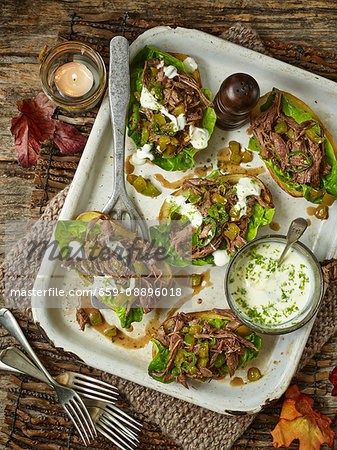 Baked potato skins, filled with spicy minted lamb shoulder and lettuce Baked potato skins, filled with spicy minted lamb shoulder and lettuce