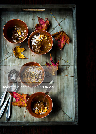 Gluten-free Mexican chocolate pudding made with avocado, almond milk, cinnamon, cayenne pepper and sea salt topped with hazelnuts and coconut flakes