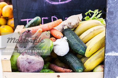 A wooden basket of different vegetables and fruits