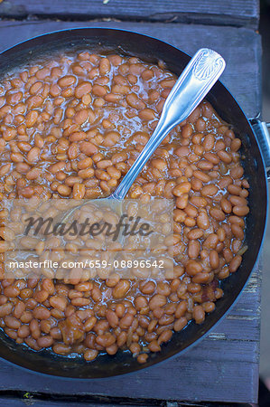 Baked beans in a pan on a wooden table