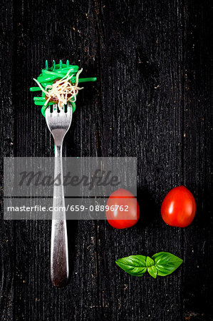 Italian pasta with tomato and basil on fork On wooden board