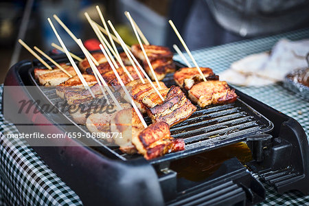 Pork belly sticks in a street kitchen