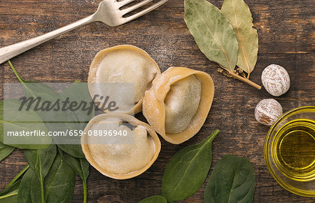Three pieces of handmade fresh tortellini gigante, stuffed with spinach and chicken surrounded Three pieces of handmade fresh tortellini gigante, stuffed with spinach and chicken surrounded