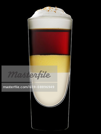 A layered drink with eggnog against a black background