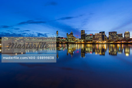 Portland Oregon downtown city skyline by Hawthorne Bridge over Willamette River waterfront during evening blue hour