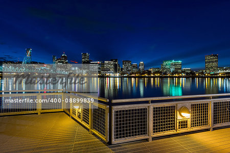 Portland Oregon downtown city skyline from Eastbank Esplanade along Willamette River waterfront during blue hour