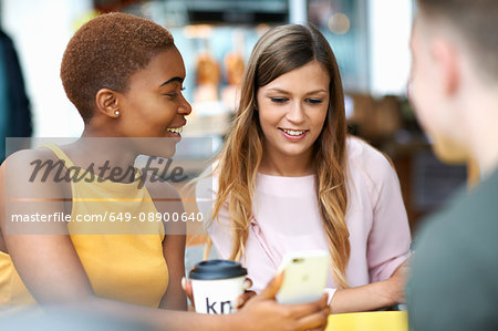 Group of friends, outdoors, looking at smartphone