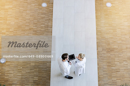 Two doctors looking at digital tablet, overhead view