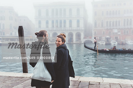 Rear view of couple on misty canal waterfront, Venice, Italy