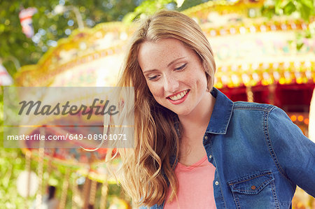 Women smiling, carousel in background, London, UK