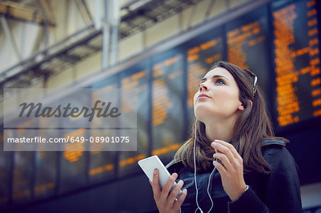 Woman looking at departure information, London, UK