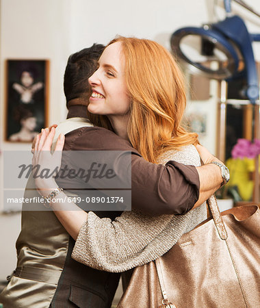 Male hairdresser hugging female customer in hair salon