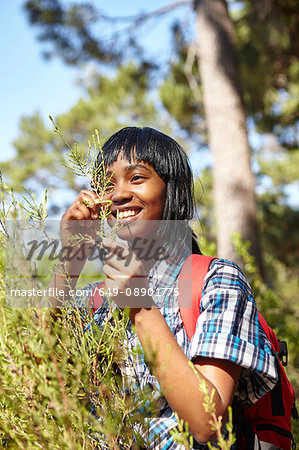 Young woman, hiking, looking at wild grass