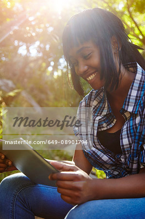 Young woman in forest, using digital tablet, Cape Town, South Africa