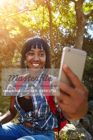 Young woman in forest, using smartphone, having video call, Cape Town, South Africa