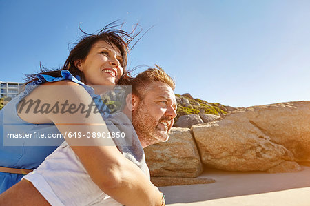 Man carrying woman on beach, Cape Town, South Africa