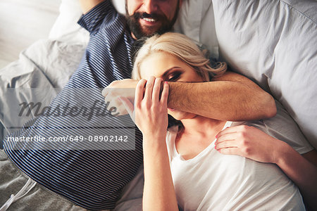 Couple relaxing on bed, fooling around