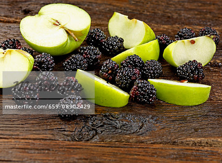 Apples and blackberries on a wooden surface
