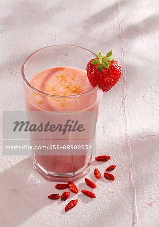 A strawberry and coconut smoothie with coconut milk and goji berries