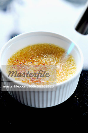 Crème brûlée being caramelised with Bunsen burner