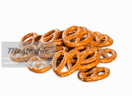 A pile of mini salted pretzels on a white surface