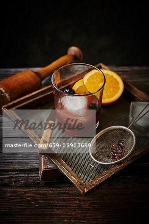 An Old Fashioned cocktail with oranges and cherries