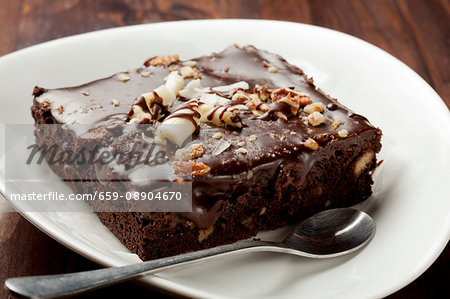 A brownie with chocolate glaze and white chocolate curls