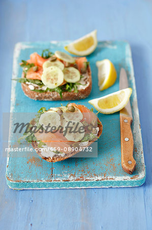 Wholemeal rolls topped with smoked salmon, cream cheese, cucumber and capers
