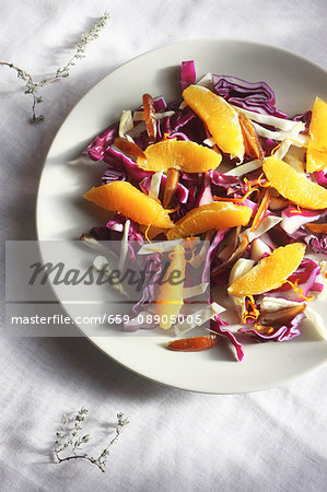 Raw winter salad with sliced cabbage, dates, oranges, lemons zest, thyme and honey