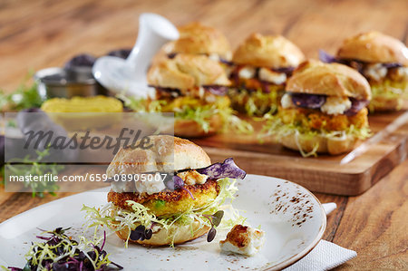 Mini veggie burgers with polenta patties, feta cheese and various types of lettuce