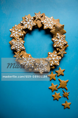 A wreath made of iced gingerbread stars on a blue background