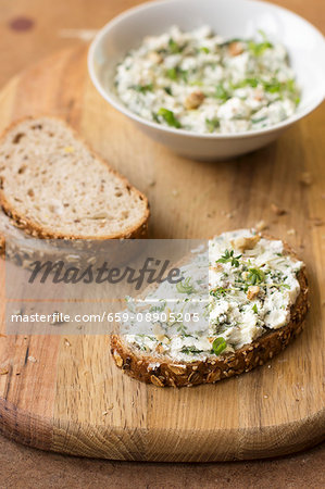 A slice of bread with goats' cheese, spring onion, dandelion greens, thyme and walnuts A slice of bread with goats' cheese, spring onion, dandelion greens, thyme and walnuts