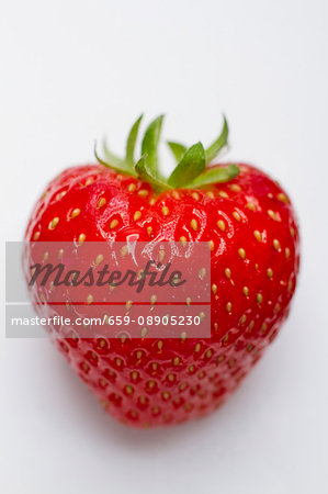 A strawberry on a white surface (close-up)