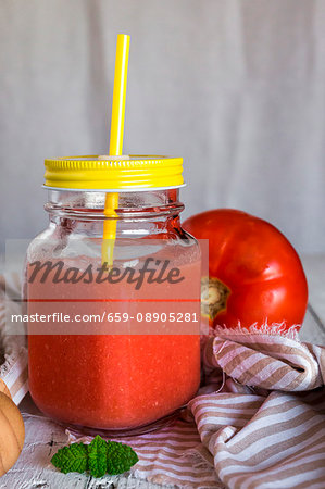 Cold tomato soup in a screw-top jar with a lid and a straw Cold tomato soup in a screw-top jar with a lid and a straw