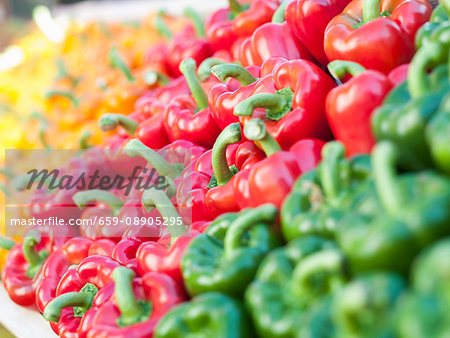 Yellow, orange, red and green peppers in wooden trays