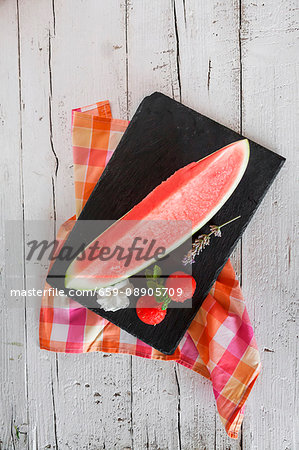 Fresh watermelon with mint and rosemary on a wooden table Fresh watermelon with mint and rosemary on a wooden table