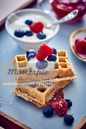 A waffle with cherries with blueberries
