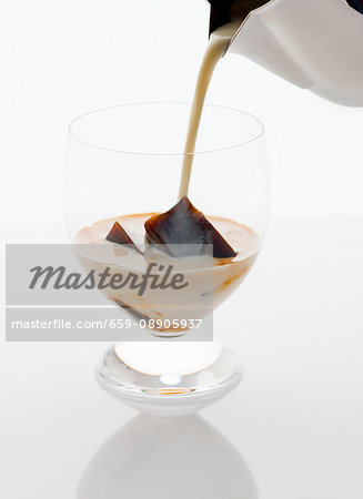 Iced coffee being poured into a glass