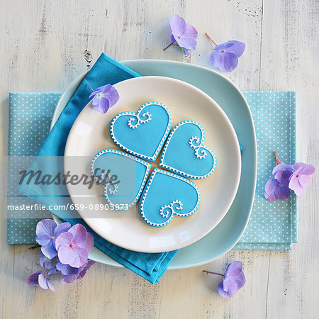 Four heart-shaped biscuits decorated with blue and white icing Four heart-shaped biscuits decorated with blue and white icing