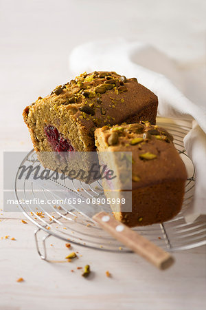 Pistachio & raspberry cake on a cooling rack