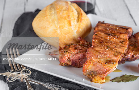 Grilled pork ribs on a plate with a knife