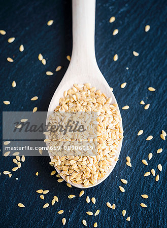 Golden flax seeds on a wooden spoon (seen from above)