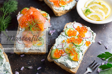 Bread topped with cream cheese, salmon, cucumber, radish and caviar