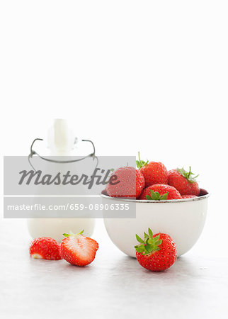 Fresh strawberries and a bottle of cream