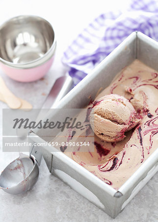 An ice cream tub with milk chocolate & blackberry ripple ice cream An ice cream tub with milk chocolate & blackberry ripple ice cream