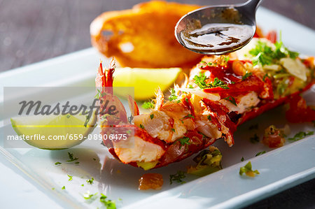 Sauce being drizzled onto half a lobster Sauce being drizzled onto half a lobster
