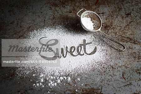 The word 'sweet' written in icing sugar